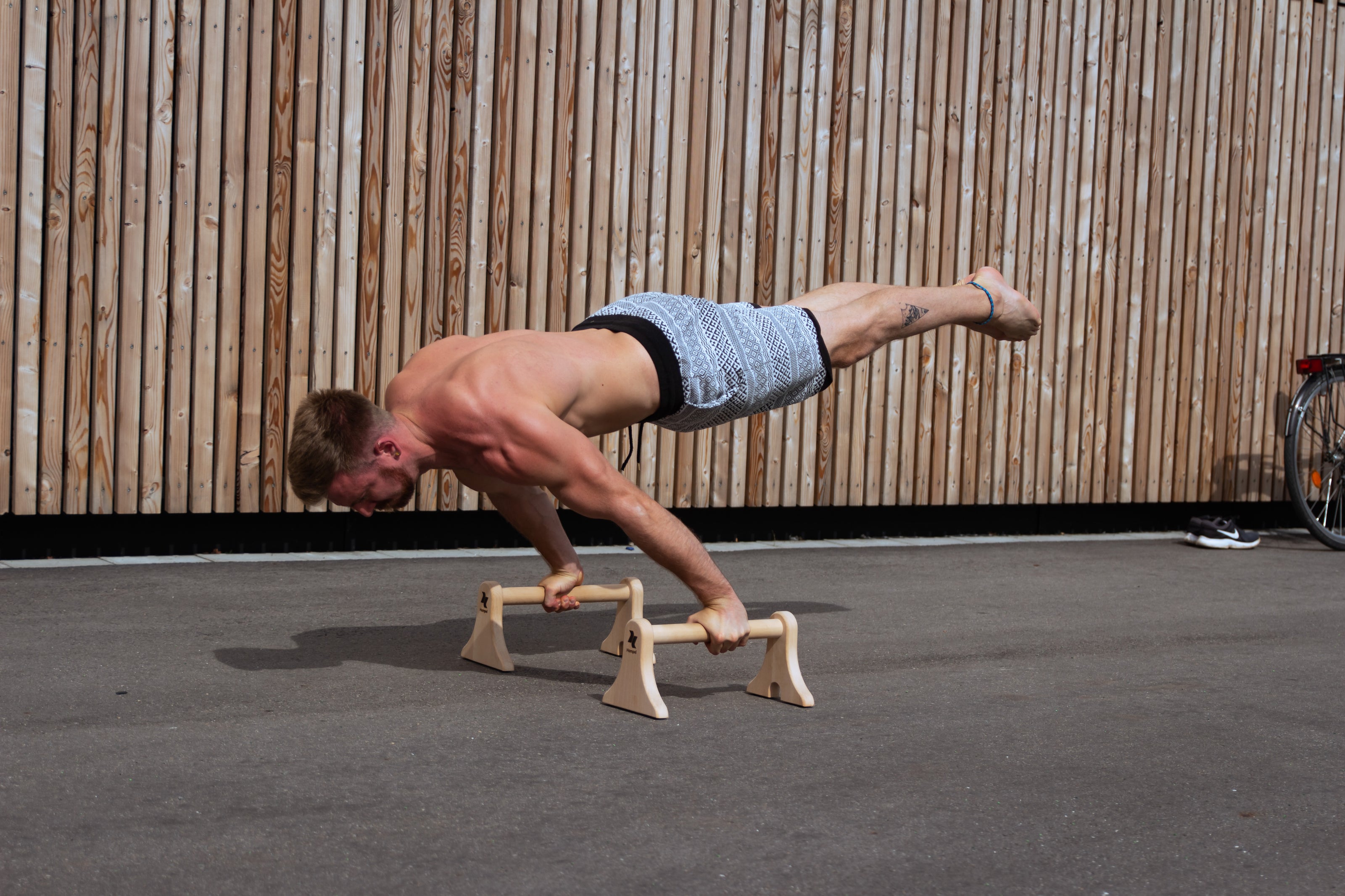 mann-macht-calisthenicsuebung-planche-auf-parallettes-maxibars